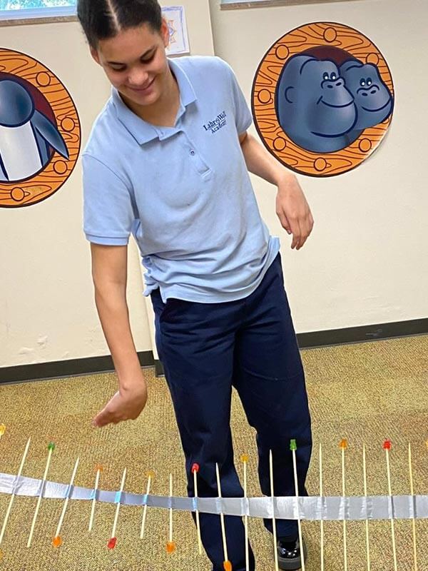 A female Lahr-Well Academy plays with a science project in the multi-purpose room.